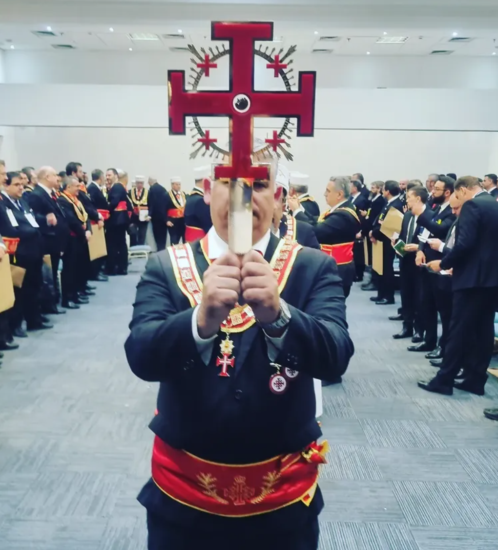Irmão eleva a Cruz da Ordem em sessão ritualística